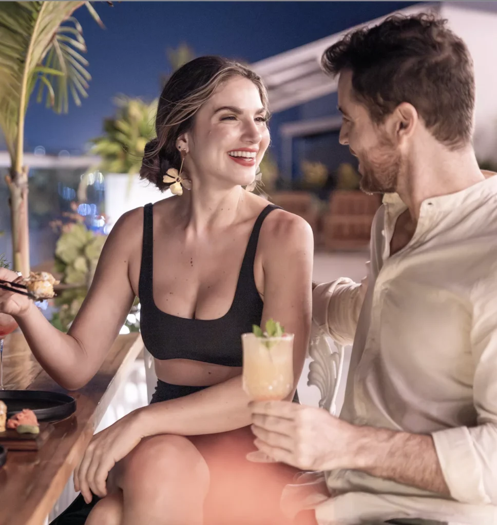 Pareja disfrutando de cócteles y sushi en Local Smiles.